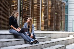 Two women sitting on steps and talking