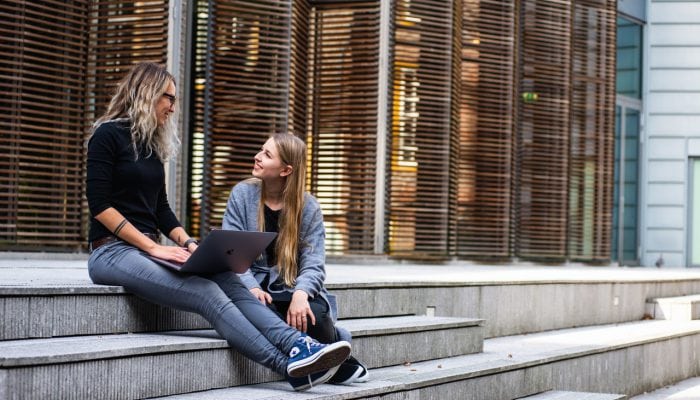 Two women sitting on steps and talking