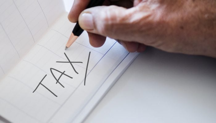 Man writing taxes on a checkbook